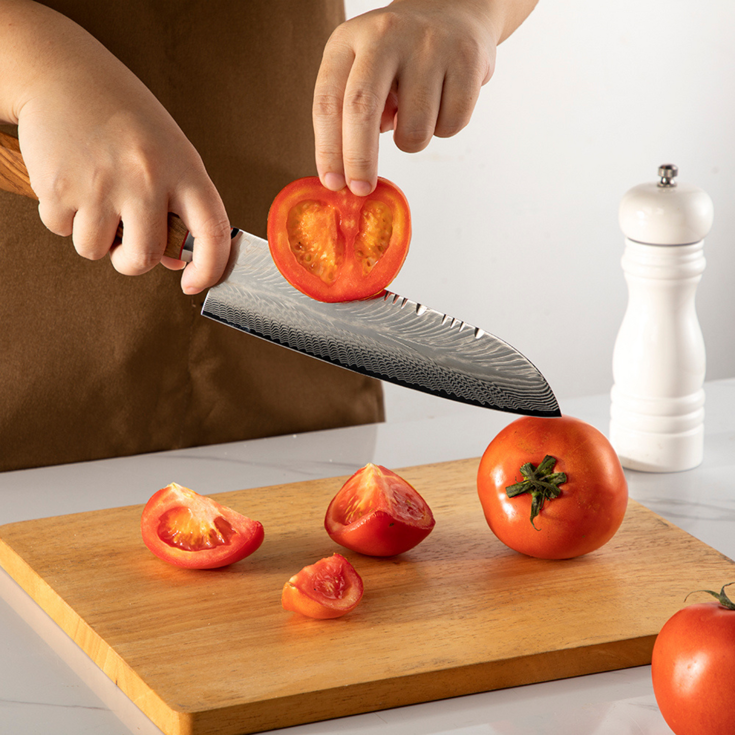 Santoku Olive Feather Messer zum Schneiden von Tomaten, mit Damastklinge und Griff aus Olivenholz.