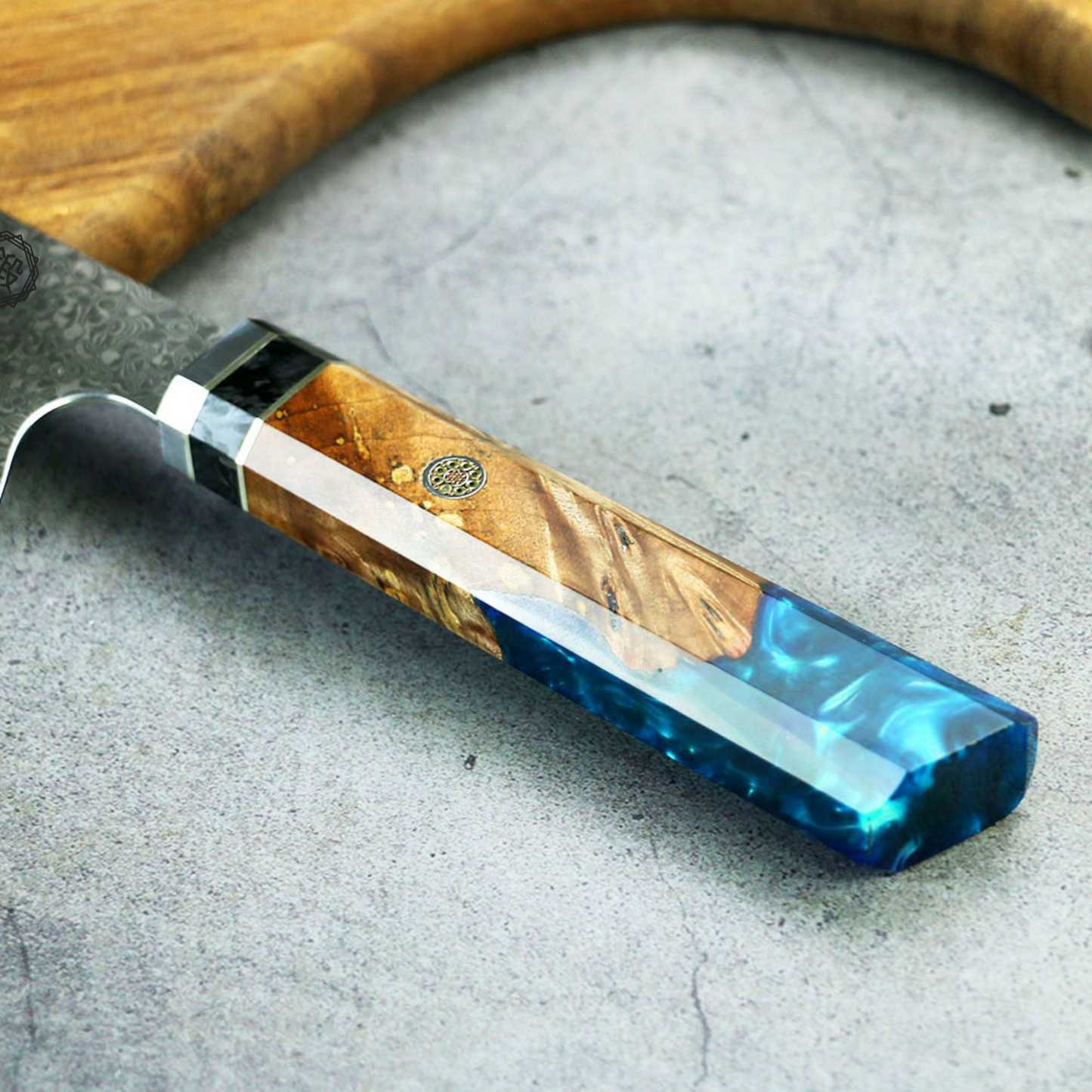 Petty Lagune-LineMesser mit handgeschliffener Damastklinge und stilvollem Holz-Epoxidharz-Griff auf strukturierter Oberfläche.